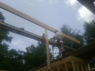 Carpenter setting a ridge beam over a new addition frame — Ice Dam Removal by Roofing Brothers in Melcher Dallas