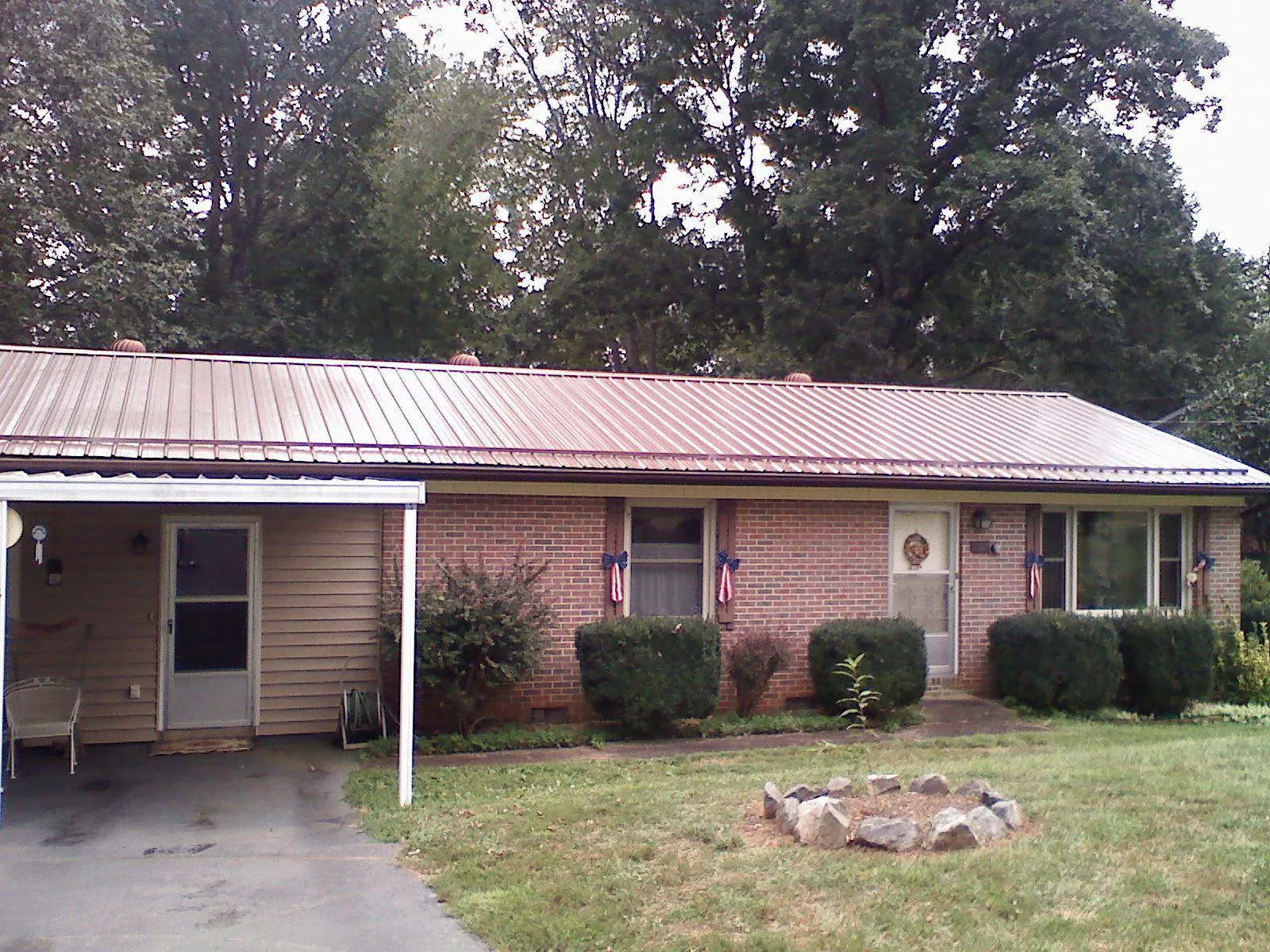 Bronze metal roof and carport on a brick ranch home — Roof Repair work by our crew in Melcher Dallas