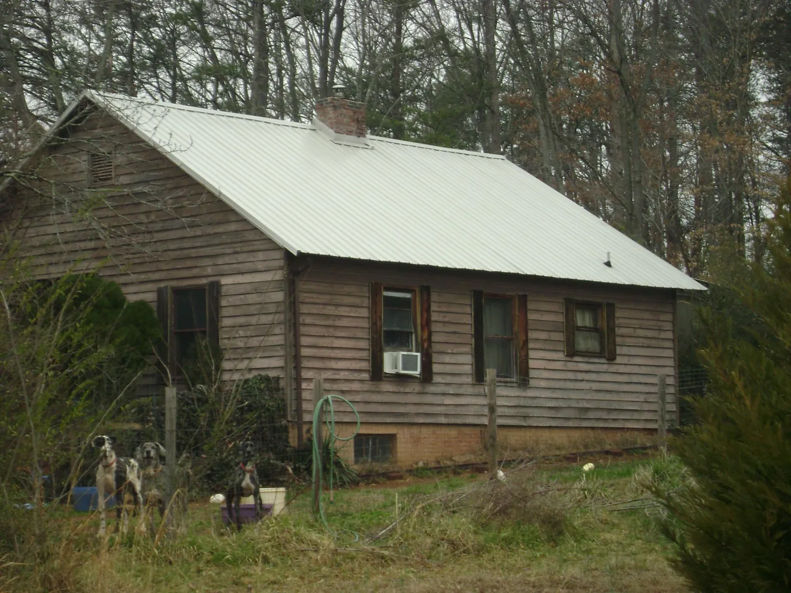 White metal roof on an old wood sided farmhouse, from a Metal Roof Installation job in Melcher Dallas